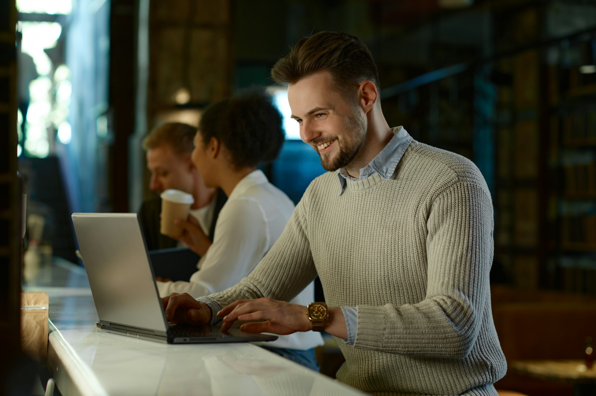 Male IT professional working on laptop in coworking space